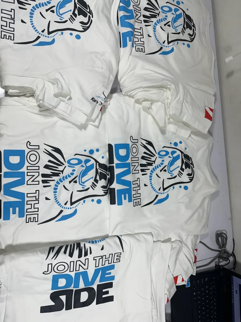 White t-shirts with bold blue print, bulk batch